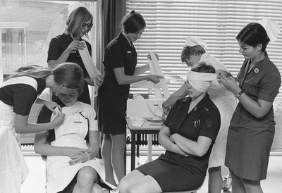 828094 Afbeelding van enkele leerling-verpleegkundigen tijdens het afleggen van het verbandexamen van de A-opleiding ...